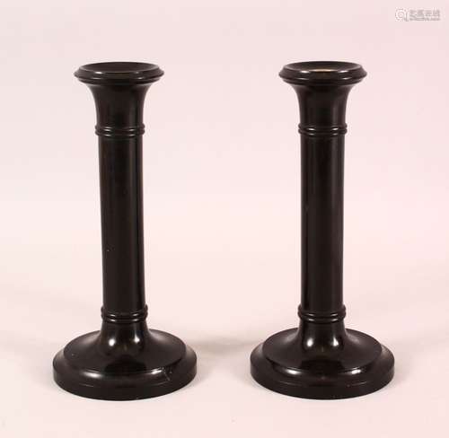 A PAIR OF INDIAN TURNED EBONY CANDLESTICKS, 20cm high.