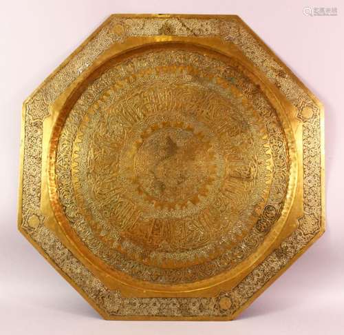 A LARGE ISLAMIC BRASS CALLIGRAPHIC CHARGER, the body carved ...