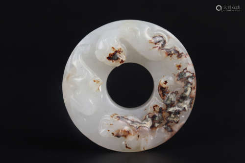A CARVED WHITE AND BROWNISH JADE ANNULAR PENDANT