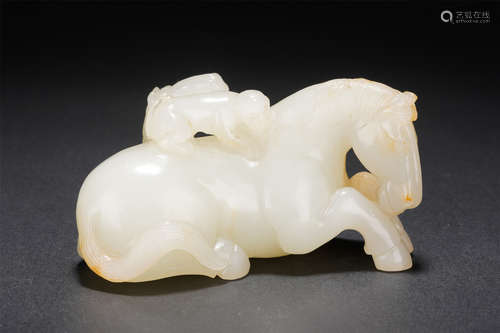 A CARVED WHITE JADE MONKEY ON HORSE