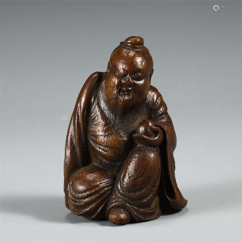 A CARVED BAMBOO SEATED FIGURE