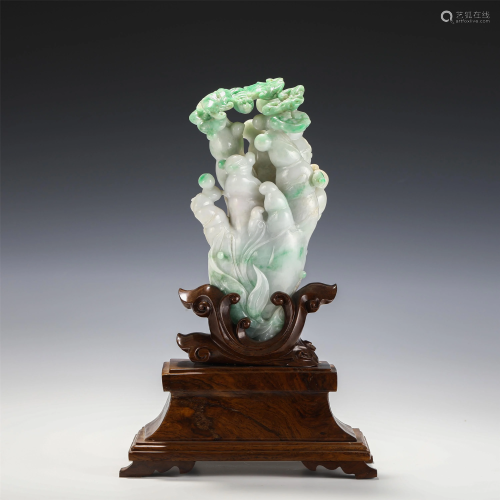 A JADEITE CARVING WITH WOODEN STAND