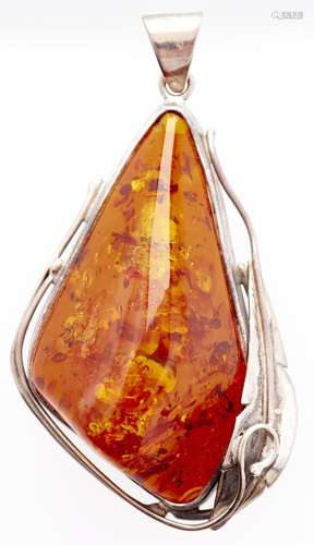 An asymmetrical amber pendant, mounted in silver