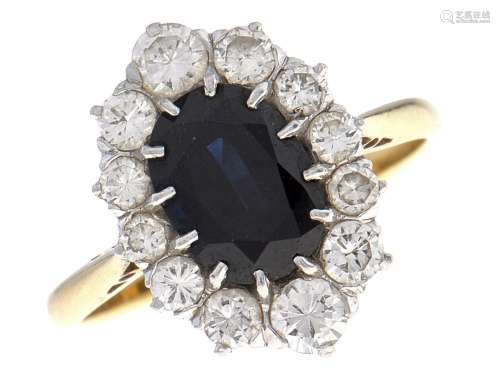 A sapphire and diamond cluster ring, the larger dark blue sa...