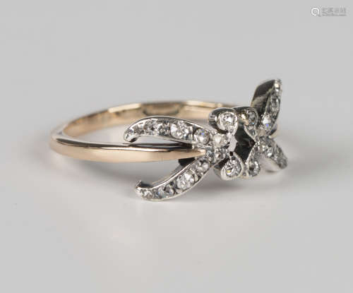 A gold, silver and diamond ring in a stylized foliate design...