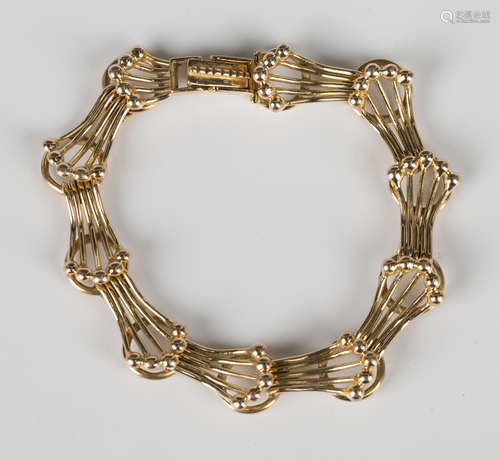 A 14ct gold bracelet in a fanned and beaded curved bar and c...