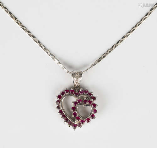 A white gold, ruby and diamond pendant, mounted with circula...