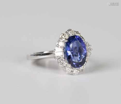 A white gold, tanzanite and diamond cluster ring, claw set w...