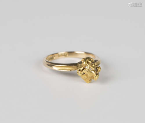 A gold ring, detailed '18ct', mounted with a gold nugget, we...