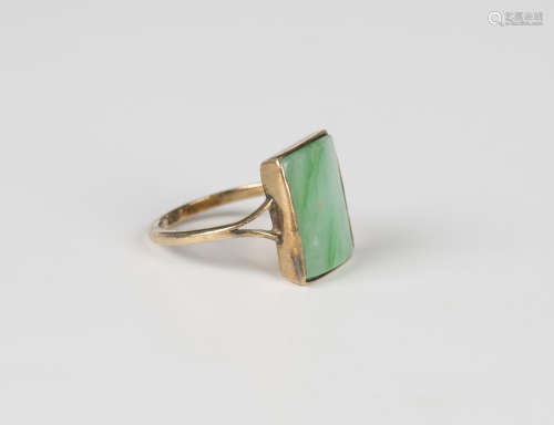 A gold ring, mounted with a curved rectangular jade, detaile...