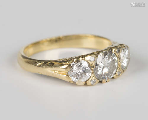 A gold and diamond three stone ring, mounted with a row of c...