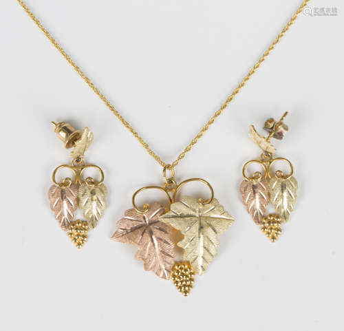 A three colour gold pendant, designed as two vine leaves and...