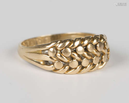 An Edwardian 18ct gold ring in a beaded and interwoven keepe...