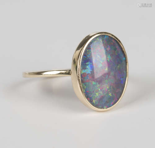 A gold ring, mounted with an oval opal doublet, unmarked, we...
