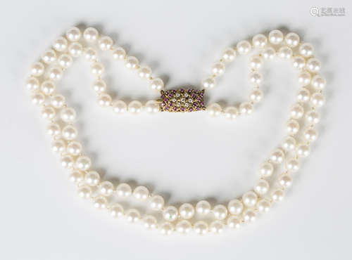 A two row necklace of cultured pearls on a gold, diamond and...