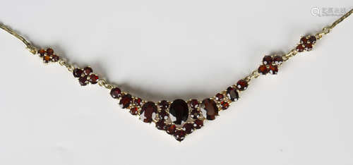 A gold and garnet necklace, claw set with oval and circular ...