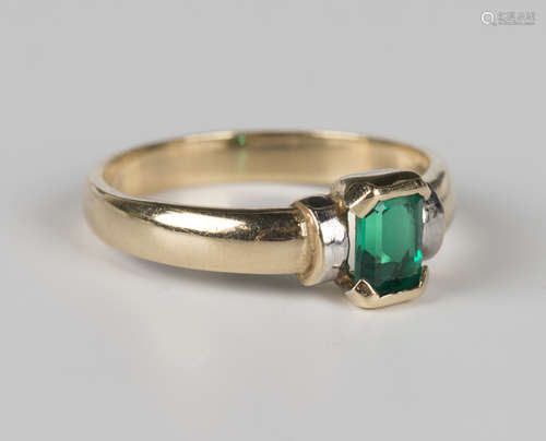 A 9ct two colour gold and synthetic green gem set solitaire ...