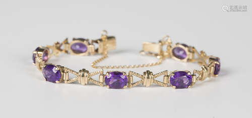 A 9ct gold and amethyst bracelet, claw set with a row of sev...