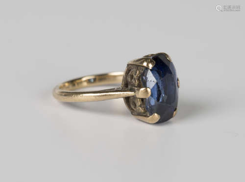 A gold ring, claw set with a cushion cut sapphire, unmarked,...