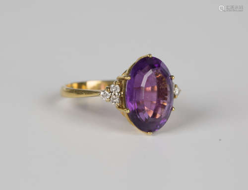 A gold ring, claw set with an oval cut amethyst between diam...