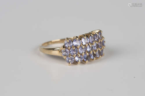 A 9ct gold and tanzanite ring, mounted with three rows of ci...