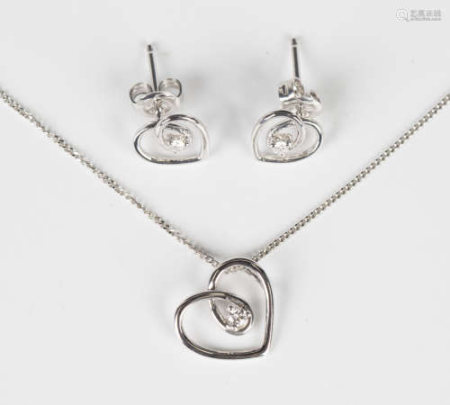 A white gold and diamond pendant in an open heart shaped des...
