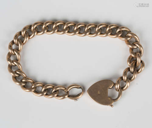 A gold hollow curblink bracelet on a gold heart shaped padlo...
