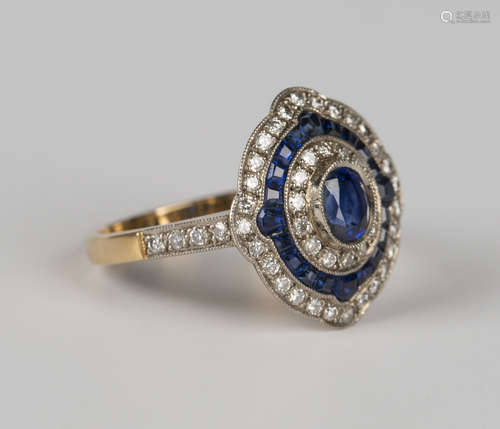 An 18ct gold, sapphire and diamond cluster ring, mounted wit...