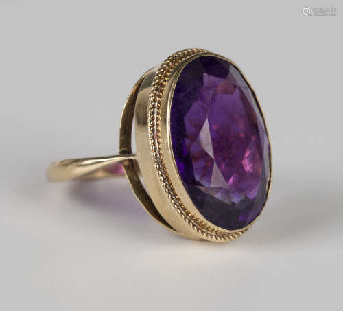 A 9ct gold ring, collet set with an oval cut amethyst within...