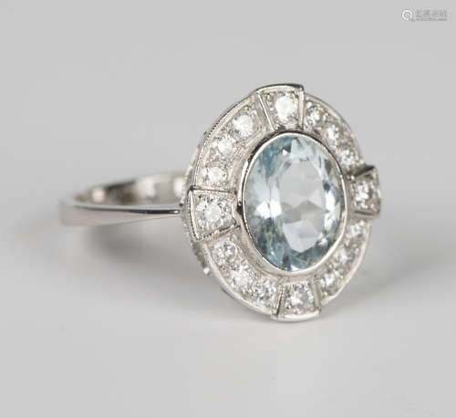 An aquamarine and diamond oval cluster ring, collet set with...