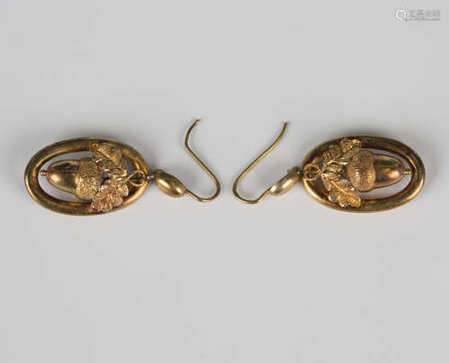 A pair of Victorian gold pendant earrings, each with a folia...