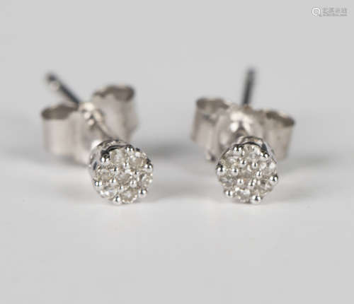 A pair of white gold and diamond seven stone cluster earstud...