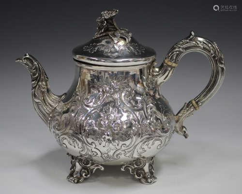 A Victorian silver teapot, the low-bellied body embossed wit...