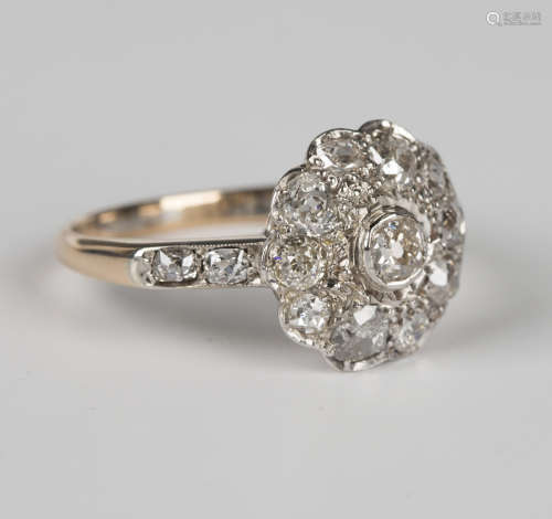A gold and diamond cluster ring, mounted with the principal ...
