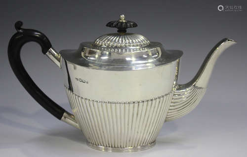 A late Victorian silver teapot of half-reeded oval tapering ...