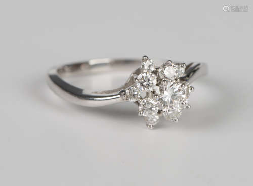 A white gold and diamond cluster ring in a star shaped twist...