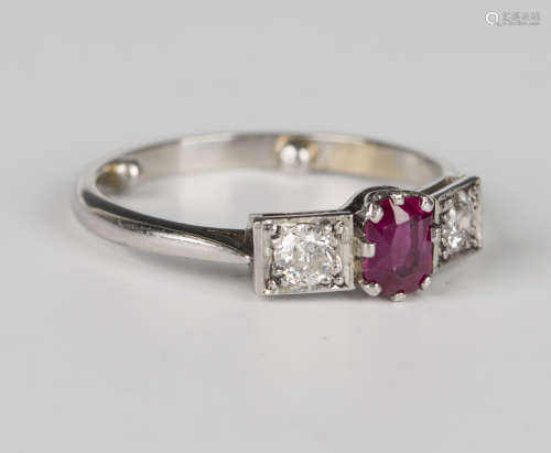 A platinum ring, claw set with a cushion cut ruby between tw...