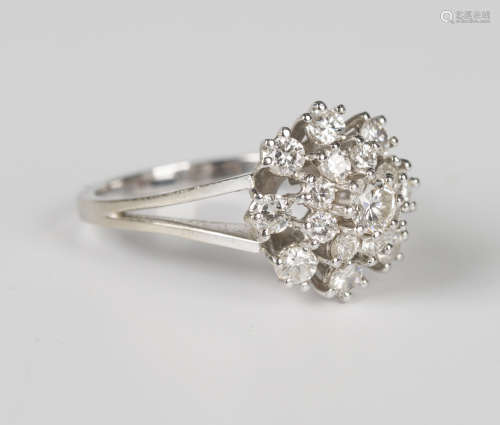 A white gold and diamond cluster ring, claw set with the pri...
