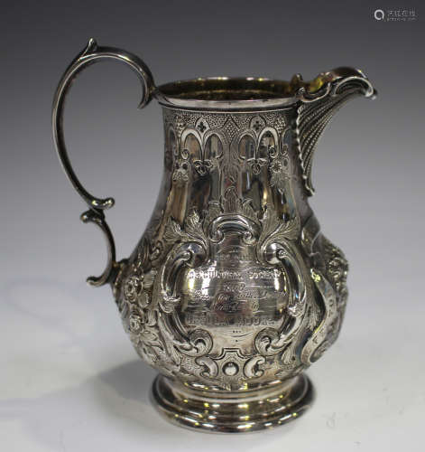 A Victorian silver milk jug of baluster form with scalloped ...