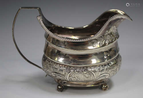 A George III silver cream jug of cushion form with gadrooned...