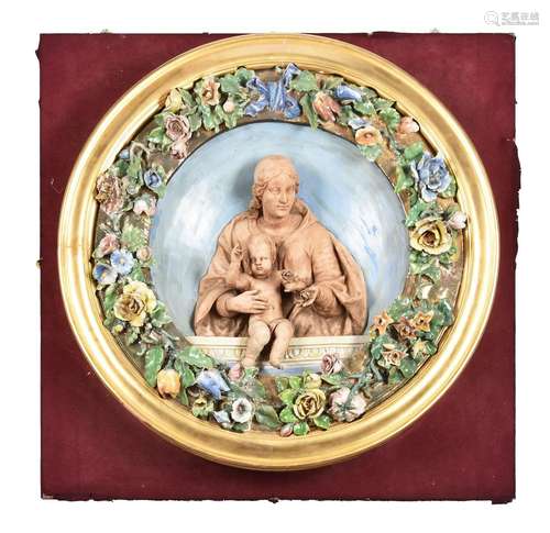 An Italian glazed and biscuit pottery relief moulded roundel...