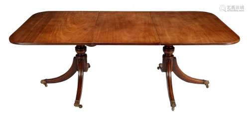 A mahogany twin pedestal dining table with one loose leaf in...