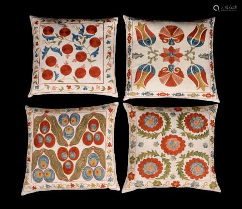 A set of four embroidered cushions in suzani style