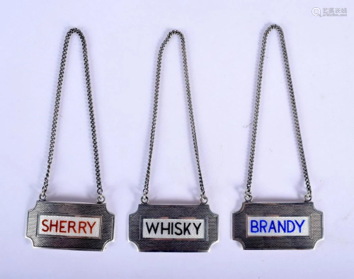 THREE 1960S SILVER AND ENAMEL DECANTER LABELS.
