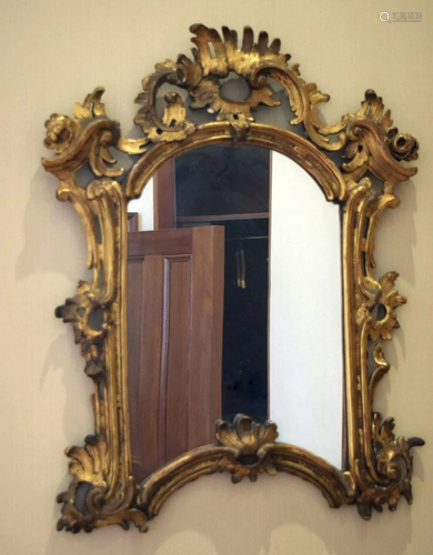 AN ANTIQUE CONTINENTAL GILTWOOD SCROLLING MIRROR with