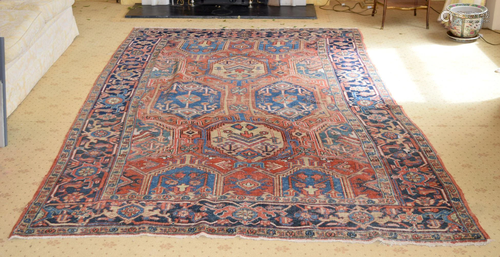 AN ANTIQUE MIDDLE EASTERN CARPET decorated with mo…