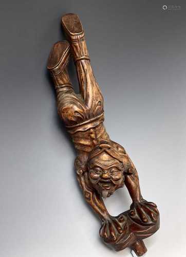 A Chinese carved hardwood figure of man walking on his hands...
