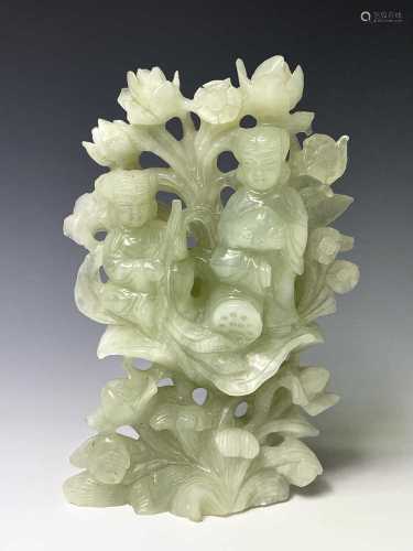 A Chinese green stone group, carved with two figures against...