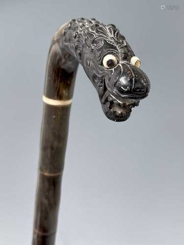 A Chinese horn walking stick, 19th century, with a carved dr...