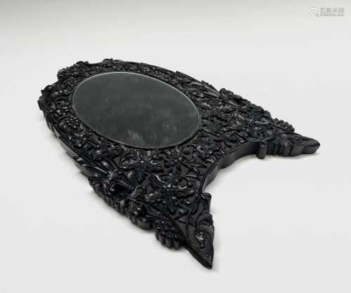 An Indian carved ebonised oval mirror, circa 1900, 22.5 x 15...